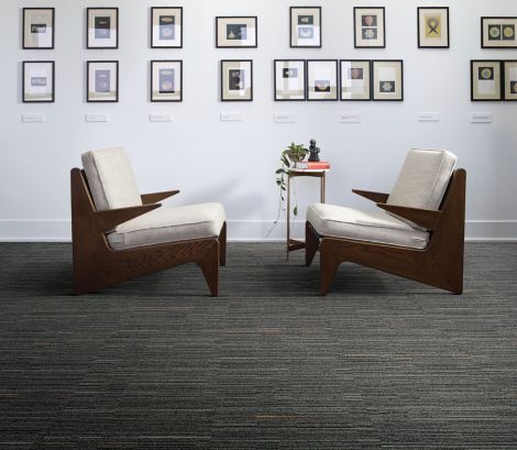 Interface Alliteration and Palindrome carpet tile in small seating area with multiple, framed prints on the wall