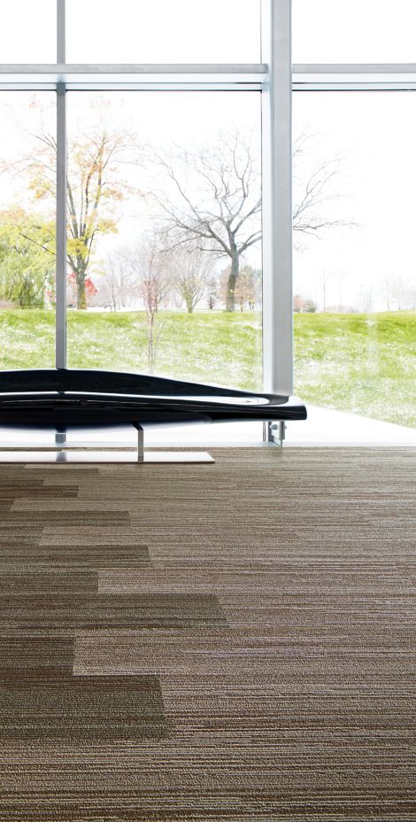 Interface Progression III plank carpet tile in room with seating area by window