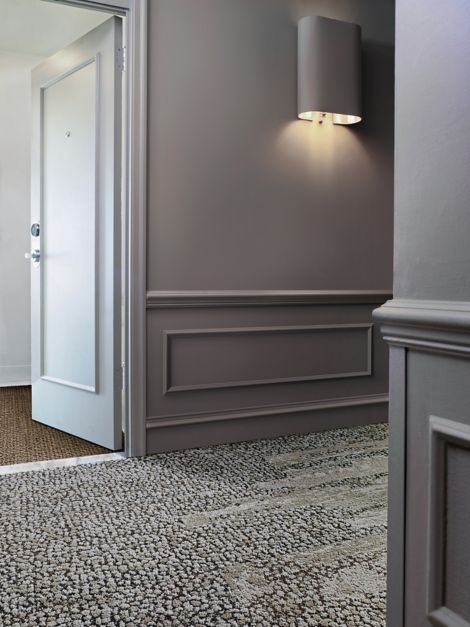 Interface HN840, HN850 and RMS 607 plank carpet tiles in hotel hallway with hotel room door ajar