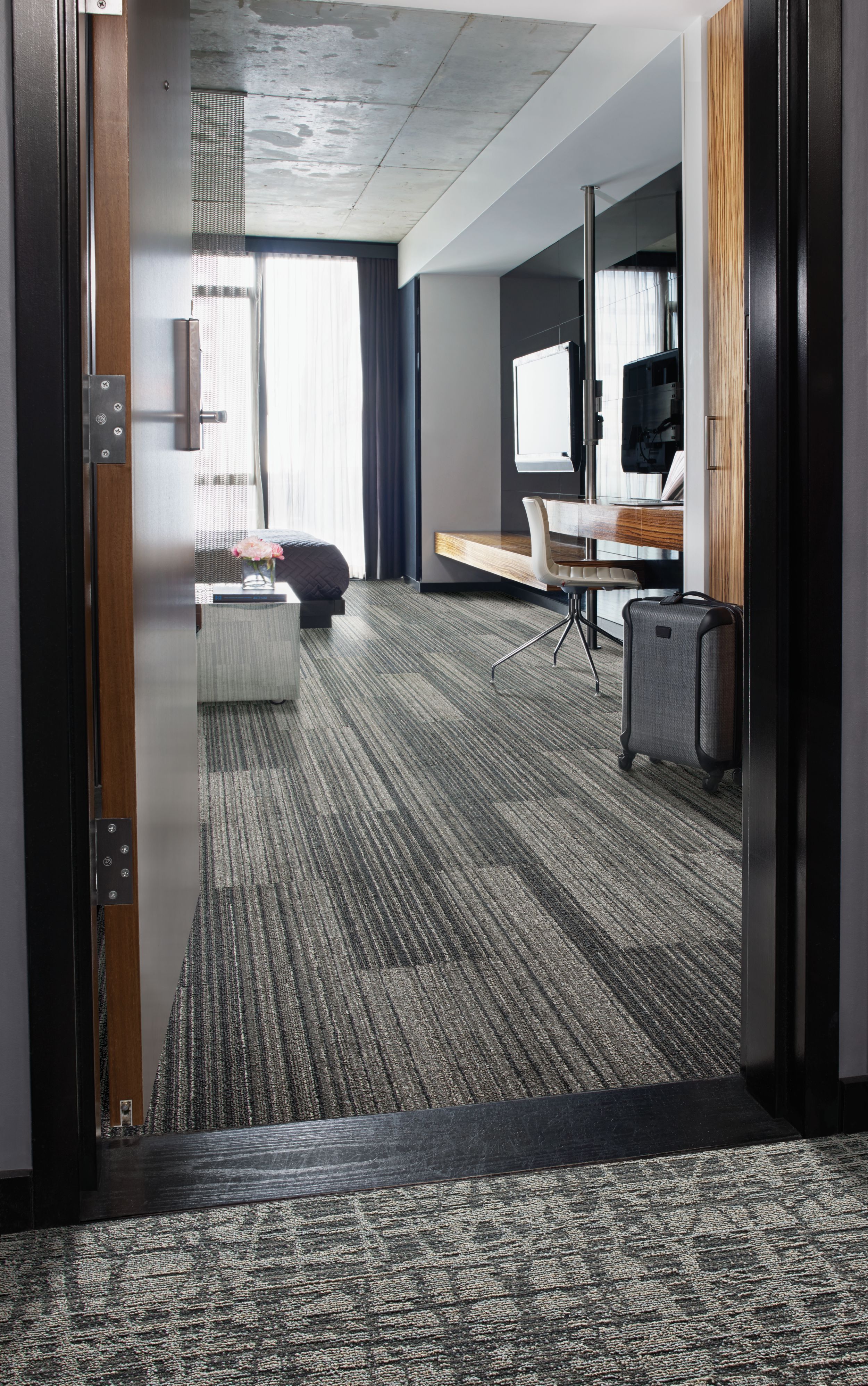 Interface RMS 509 and WE153 plank carpet tile in hotel guest room with black suitcase imagen número 1