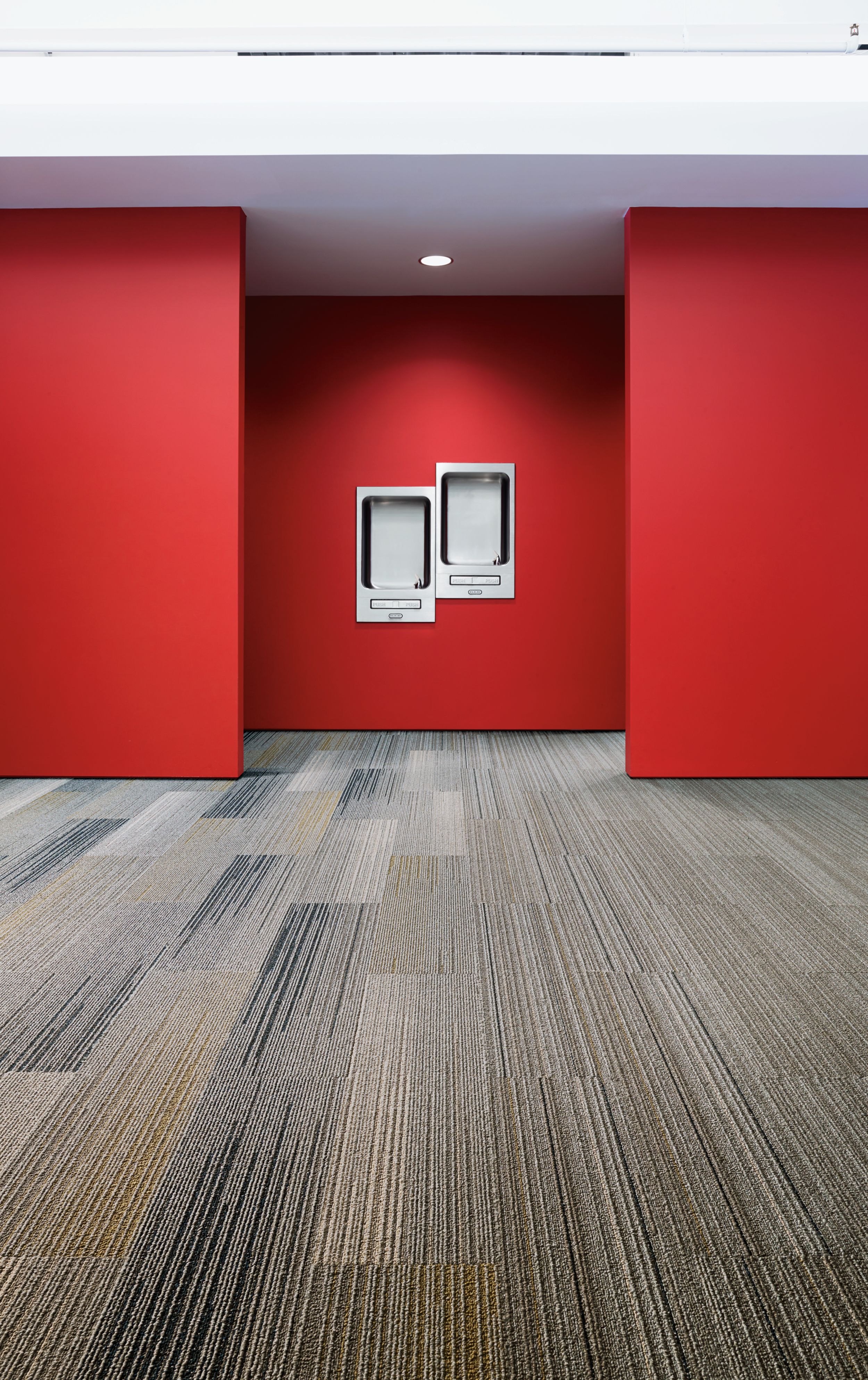 Interface SL910 and SL930 plank carpet tile in water fountain area with red walls imagen número 4
