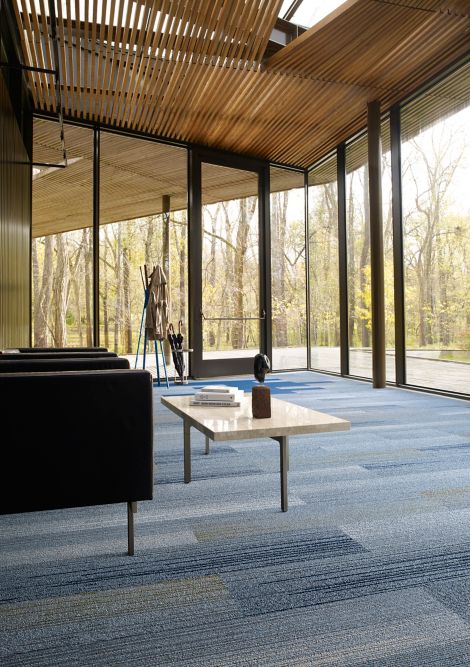 Interface SL910 and SL930 plank carpet tile in room with glass walls, wood ceiling and two chairs with table imagen número 4