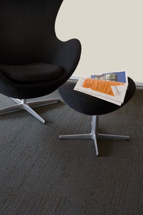 Detail of Interface San Roco carpet tile with chair and ottoman