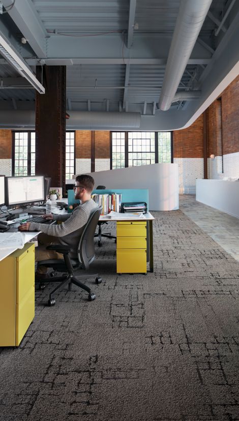 Interface Kerbstone and Sett in Stone carpet tile with Textured Stones LVT in desk area with man working at computer image number 2