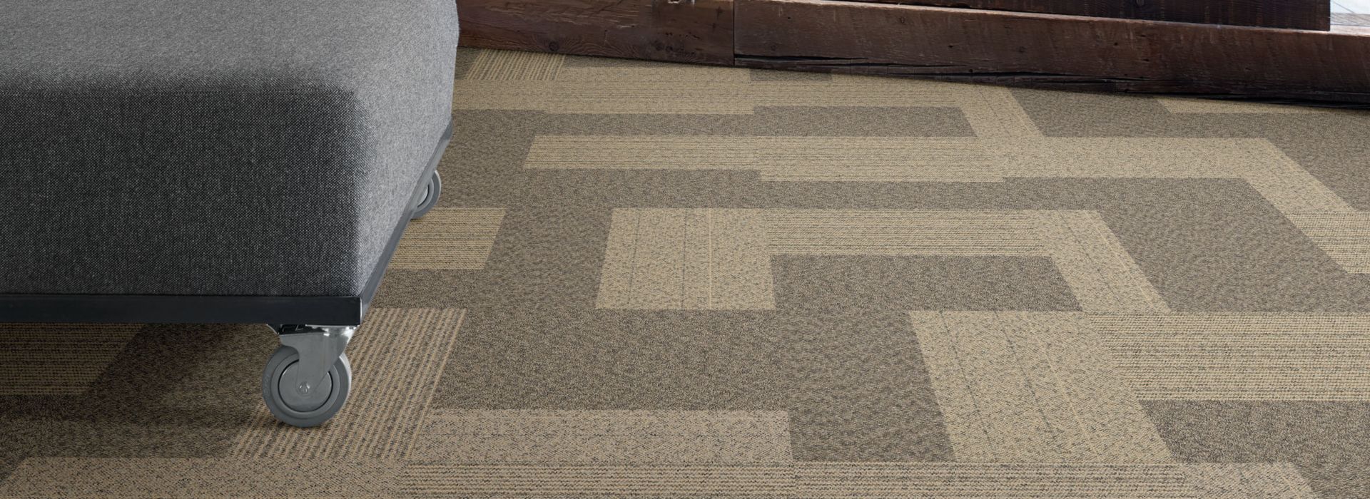 Interface ShadowBox Loop carpet tile in office common area with wooden wall and bench