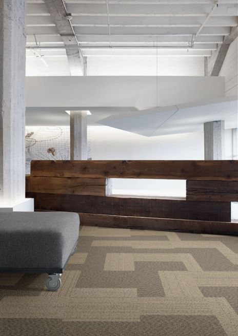 Interface ShadowBox Loop carpet tile in office common area with wooden wall and bench
