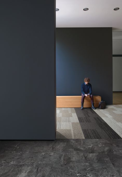 Interface ShadowBox Loop carpet tile and Natural Stone LVT in open area with man seated on bench imagen número 3