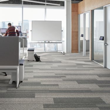 Interface Shiver Me Timbers plank carpet tile in office with man standing at desk