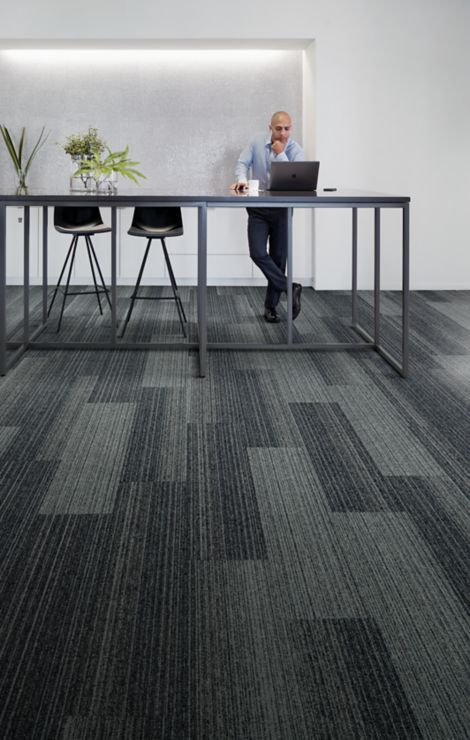 Interface Shiver Me Timbers plank carpet tile with man at high table with computer