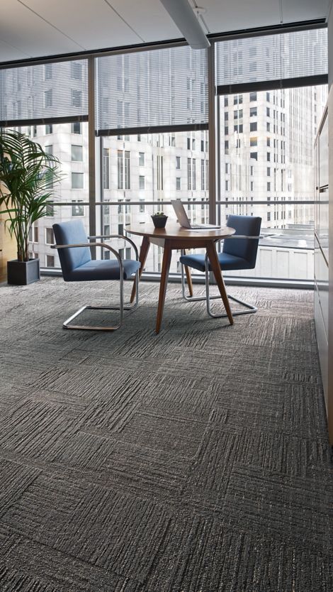 Interface Striation carpet tile in office with glass walls, large plant and small table with chairs