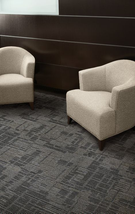 Interface Syncopation carpet tile in seating area with two chairs and wood walls