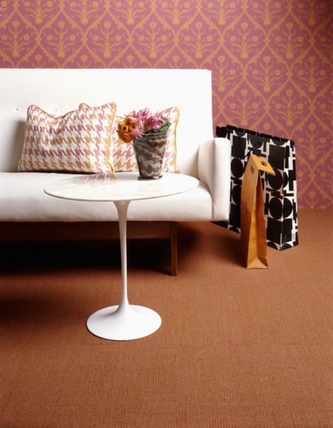 Interface Syncopation carpet tile in seating area with sofa, small whitie table with plant and shopping bags