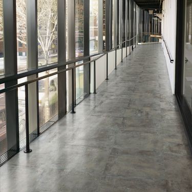 Interface Textured Stones LVT in corridor with railing