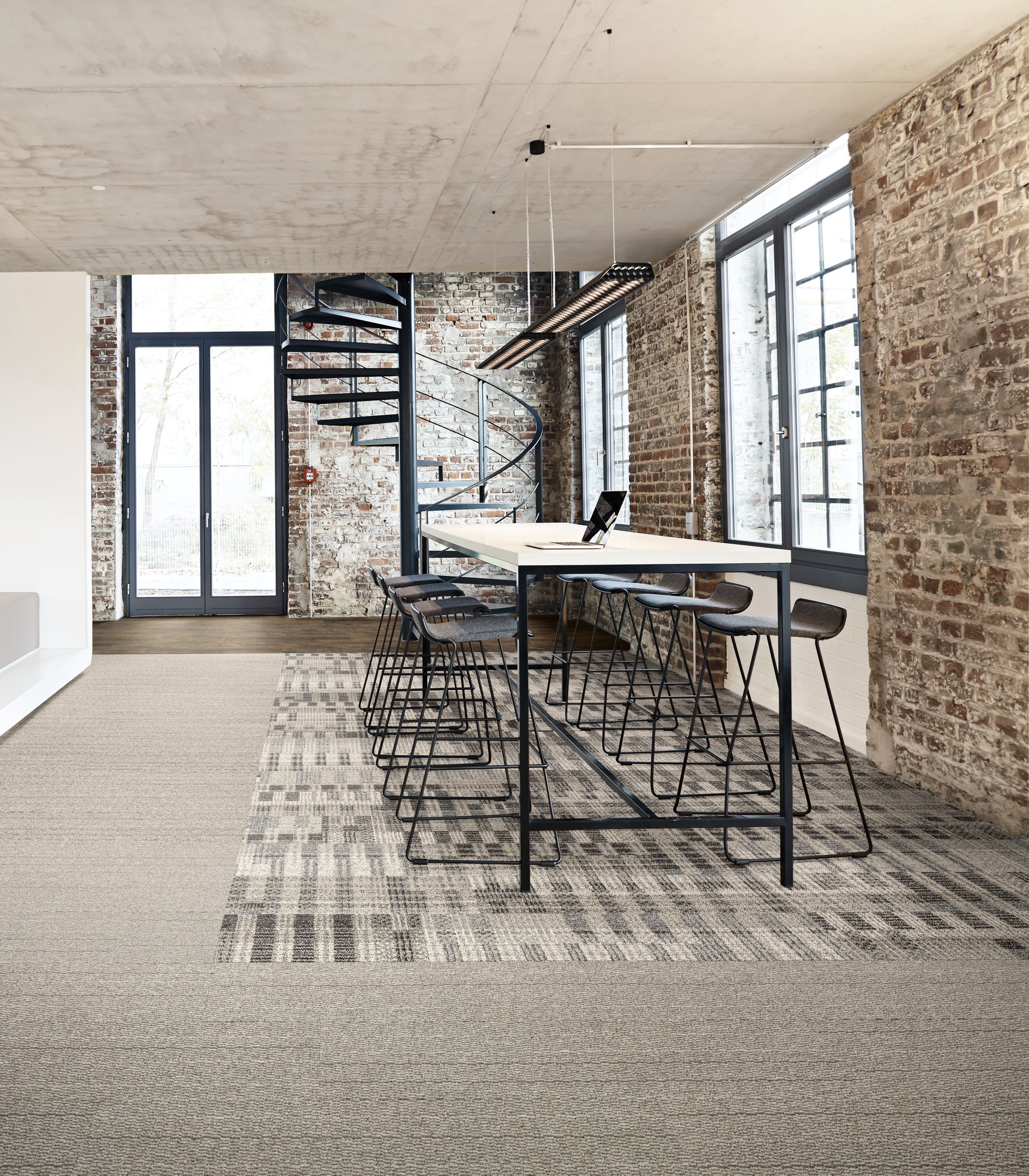 Interface Loom of Life and Tangled & Taut plank carpet tile with Textured Woodgrains LVT in seating area with brick walls and spiral staircase in background image number 7