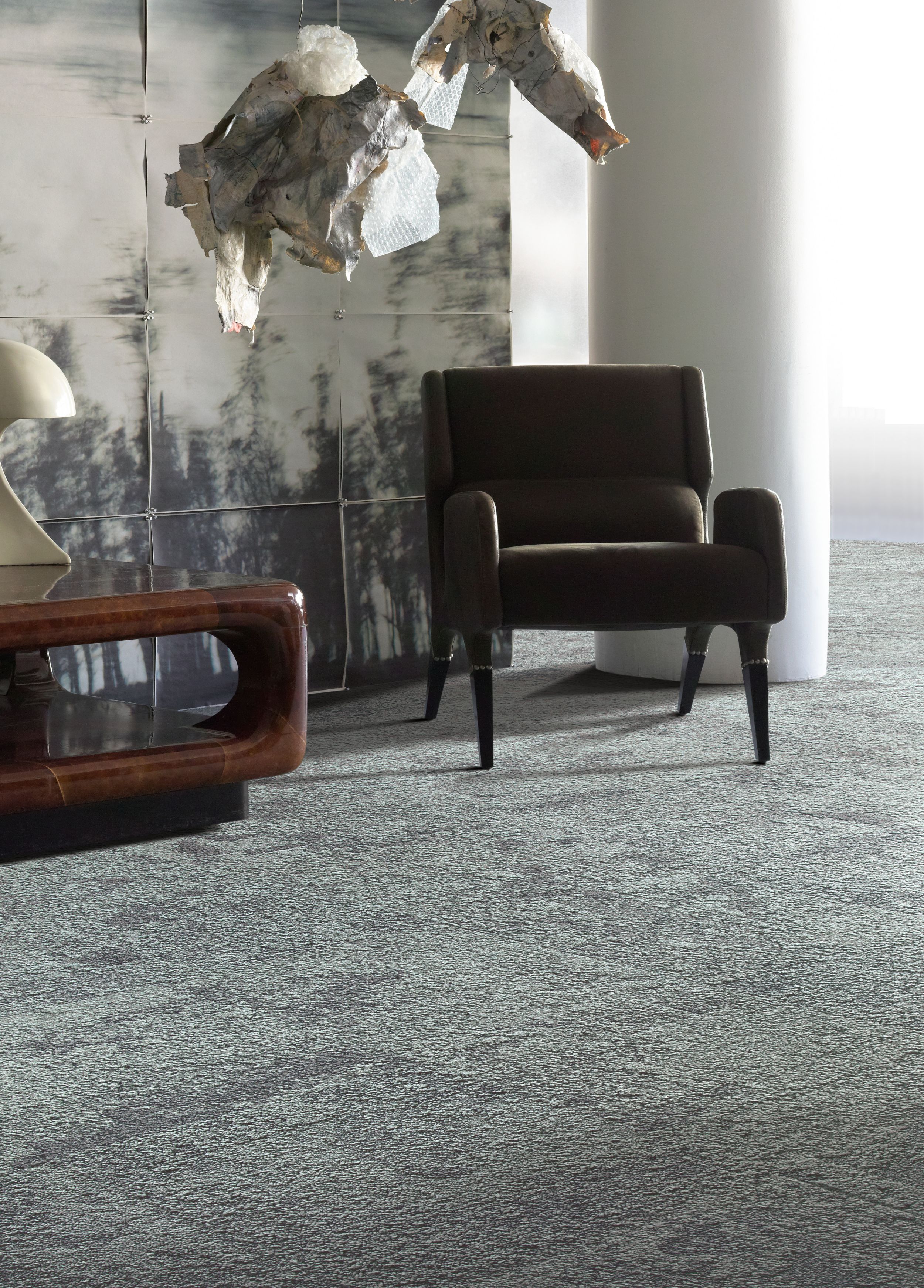Interface UR103 carpet tile in seating area with chair, hanging sculpture and wood side table imagen número 5