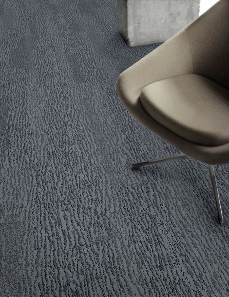 Detail of Interface Velvet Bark carpet tile with chair