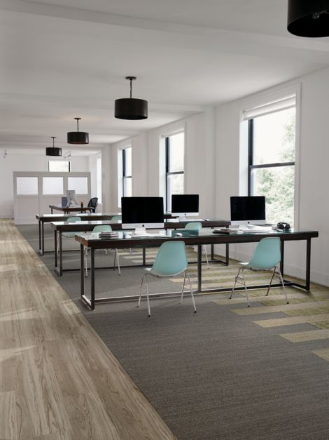 Interface WW860 and WW895 plank carpet tile in open work area with teal chairs