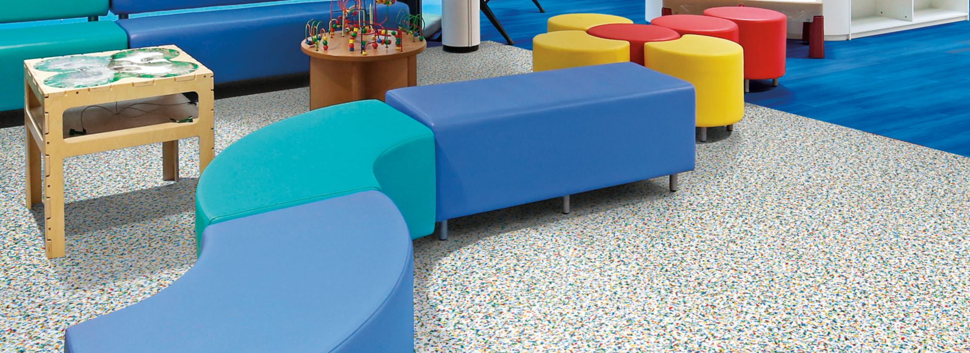 Interface Walk on By and Studio Set LVT in children's waiting area with colorful furniture