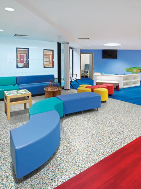Interface Walk on By and Studio Set LVT in children's waiting area with colorful furniture