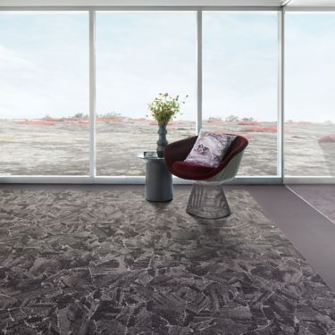 Interface Mile Rock carpet tile and Brushed Lines LVT in open room with chair and side table with plant image number 1