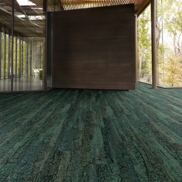 Interface Granite Peak plank carpet tile in open area with wood ceiling and wood accent wall imagen número 1