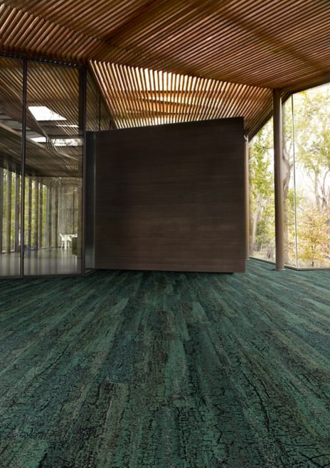 Interface Granite Peak plank carpet tile in open area with wood ceiling and wood accent wall
