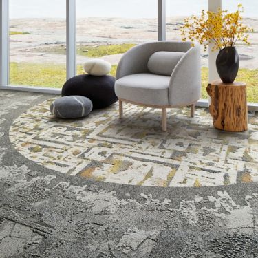 Interface Bridge Creek, Mountain Rock and Panola Mountain carpet tile in seating area with taupe chair and wood side table