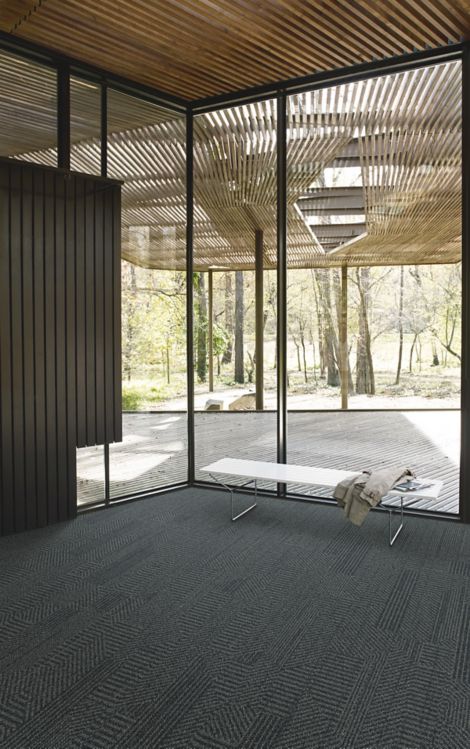 Interface Open Air 407 plank carpet tile in corner space with jacket draped over small white bench and wood slat ceiling