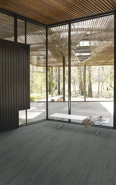 Interface Open Air 408 plank carpet tile in corner space with jacket draped over small white bench and wood slat ceiling imagen número 7