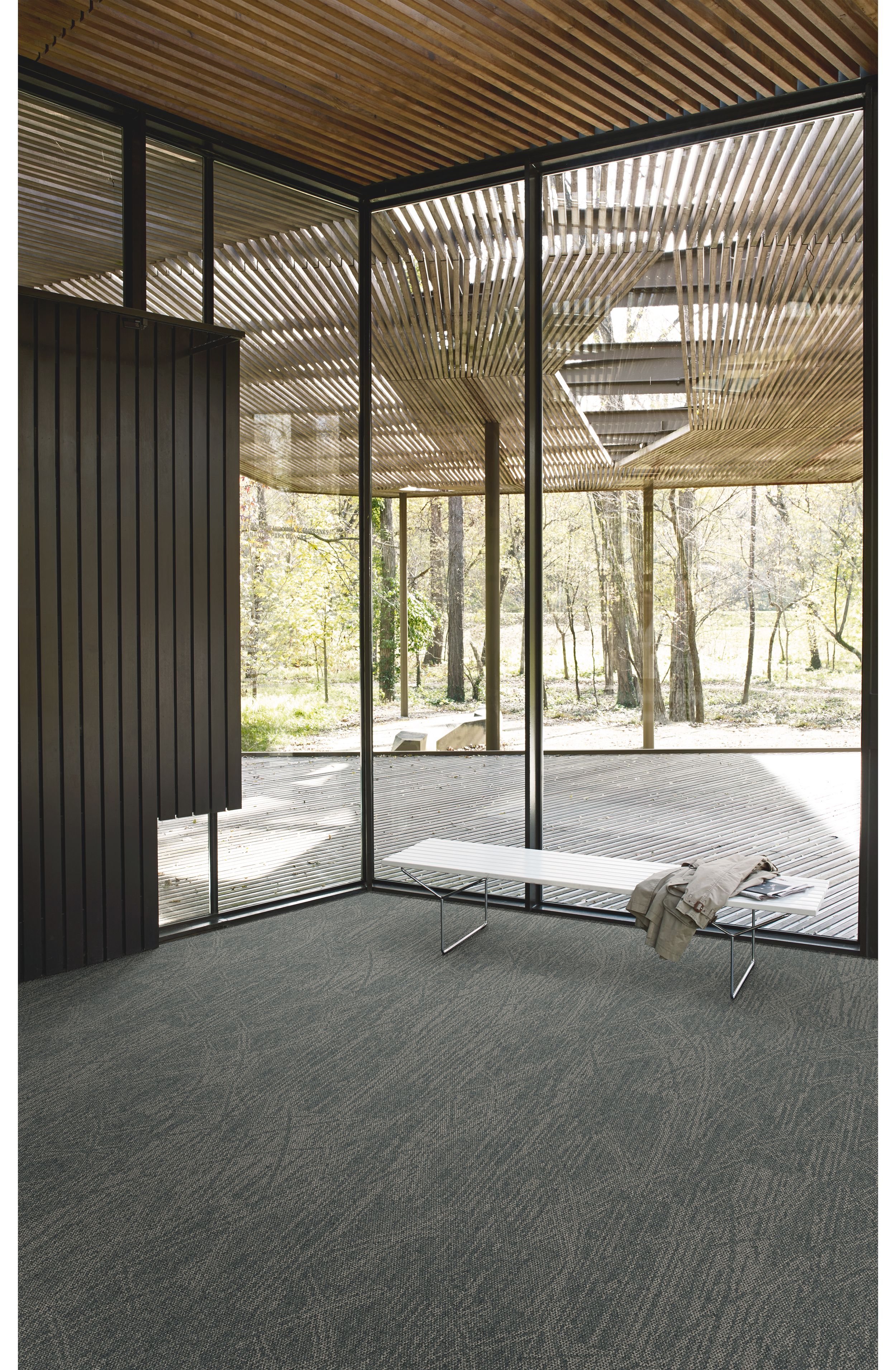 Interface Open Air 409 plank carpet tile in corner space with jacket draped over small white bench and wood slat ceiling numéro d’image 4