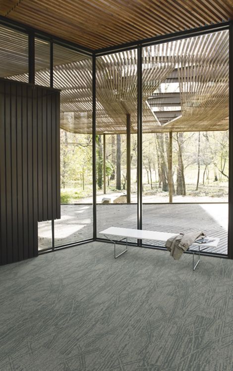 Interface Open Air 409 plank carpet tile in corner space with jacket draped over small white bench and wood slat ceiling