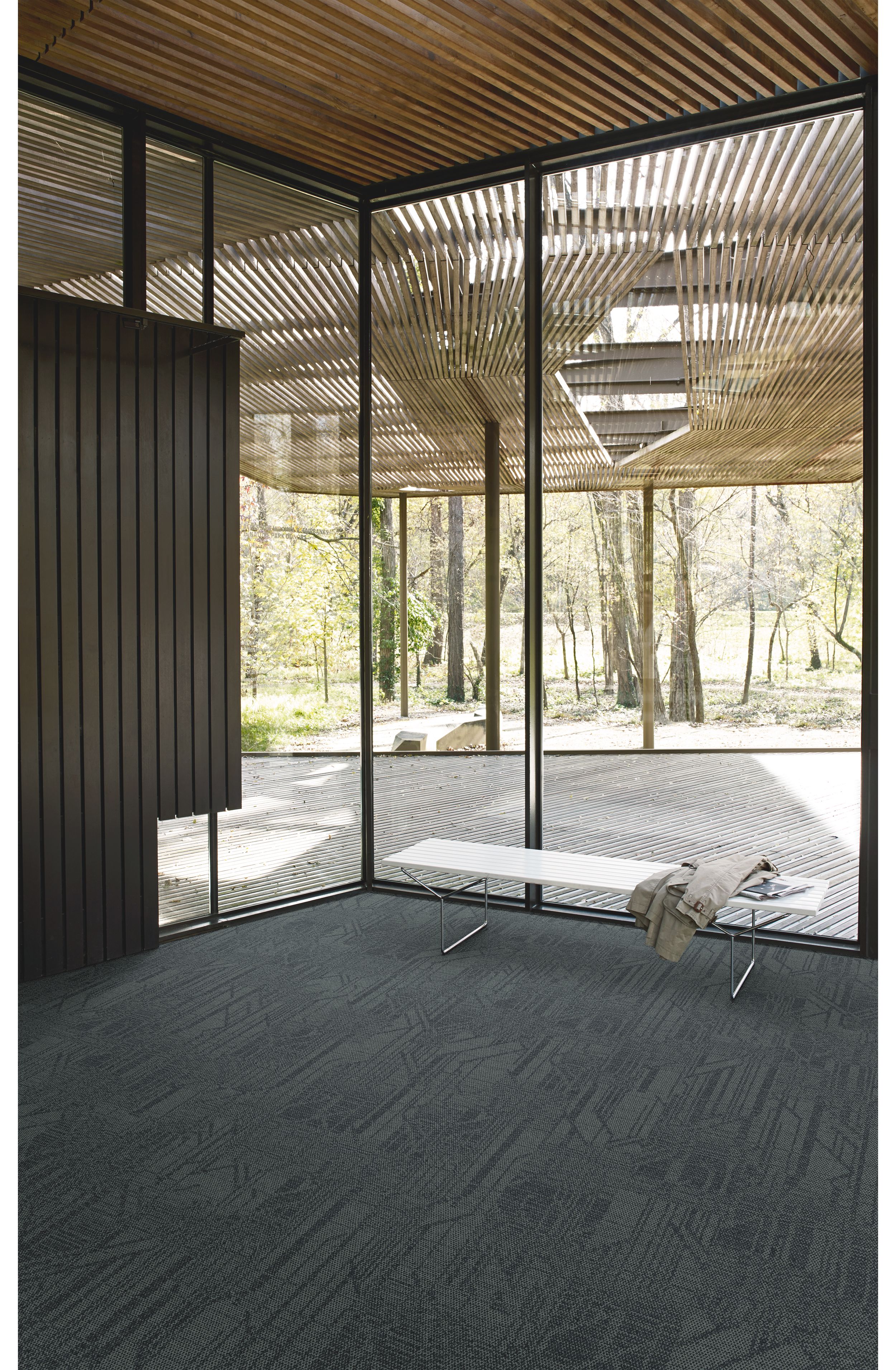 Interface Open Air 411 plank carpet tile in corner space with coat draped over small white bench image number 2