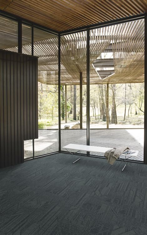 Interface Open Air 411 plank carpet tile in corner space with coat draped over small white bench