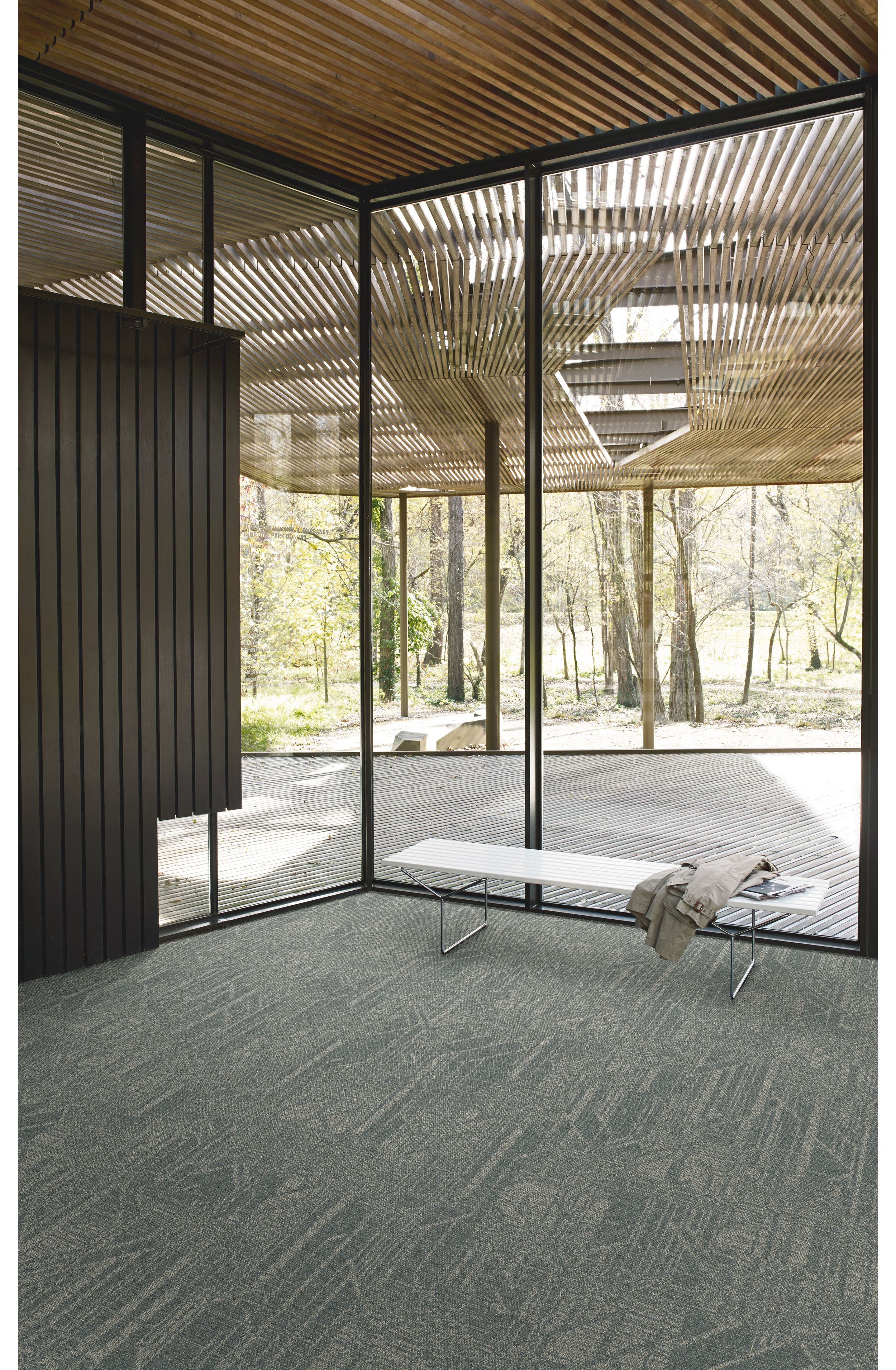 Interface Open Air 411 plank carpet tile in corner space with coat draped over small white bench image number 4