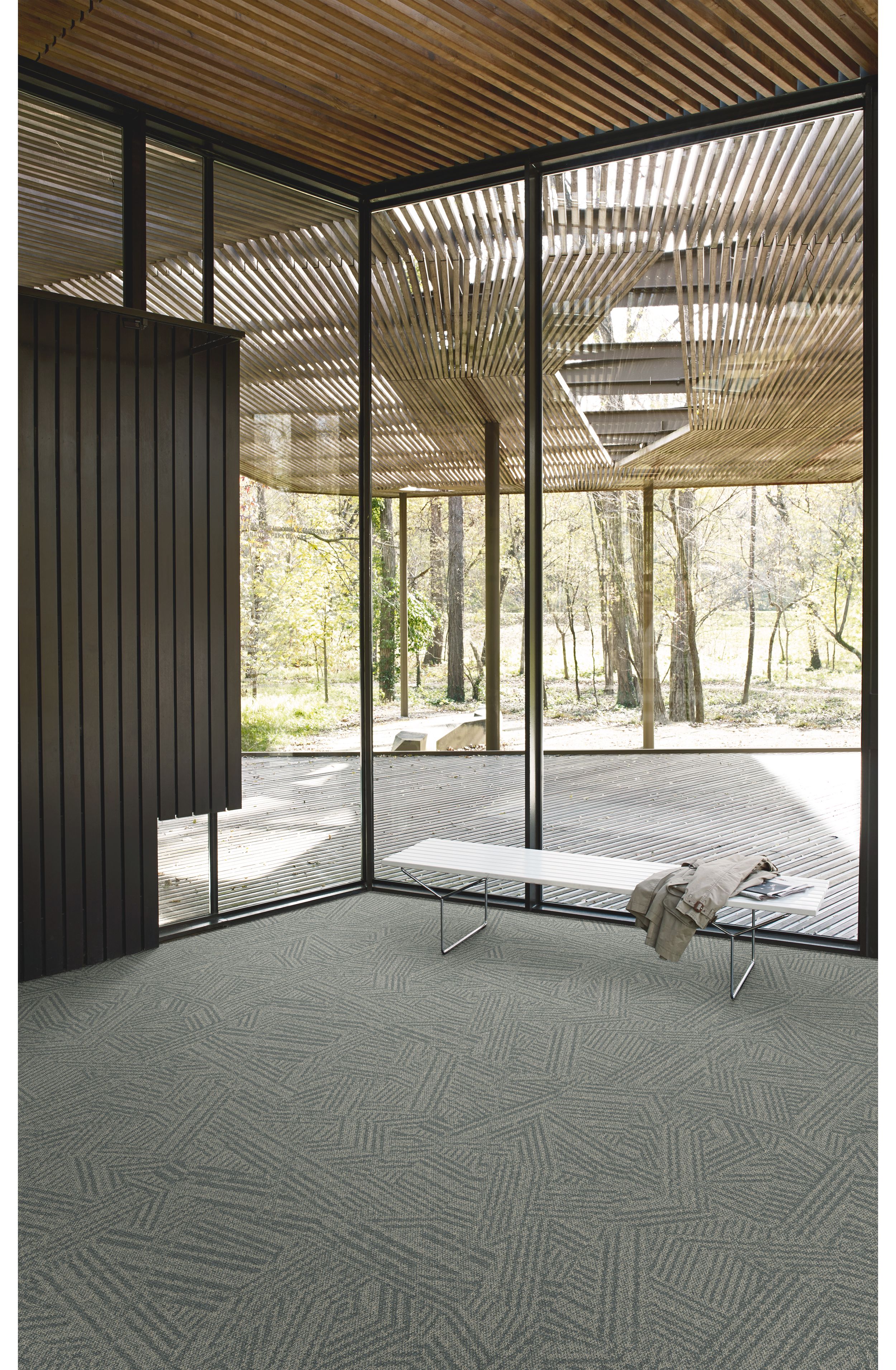 Interface Open Air 412 carpet tile in corner space with coat draped over small white bench and wood slat ceiling imagen número 3