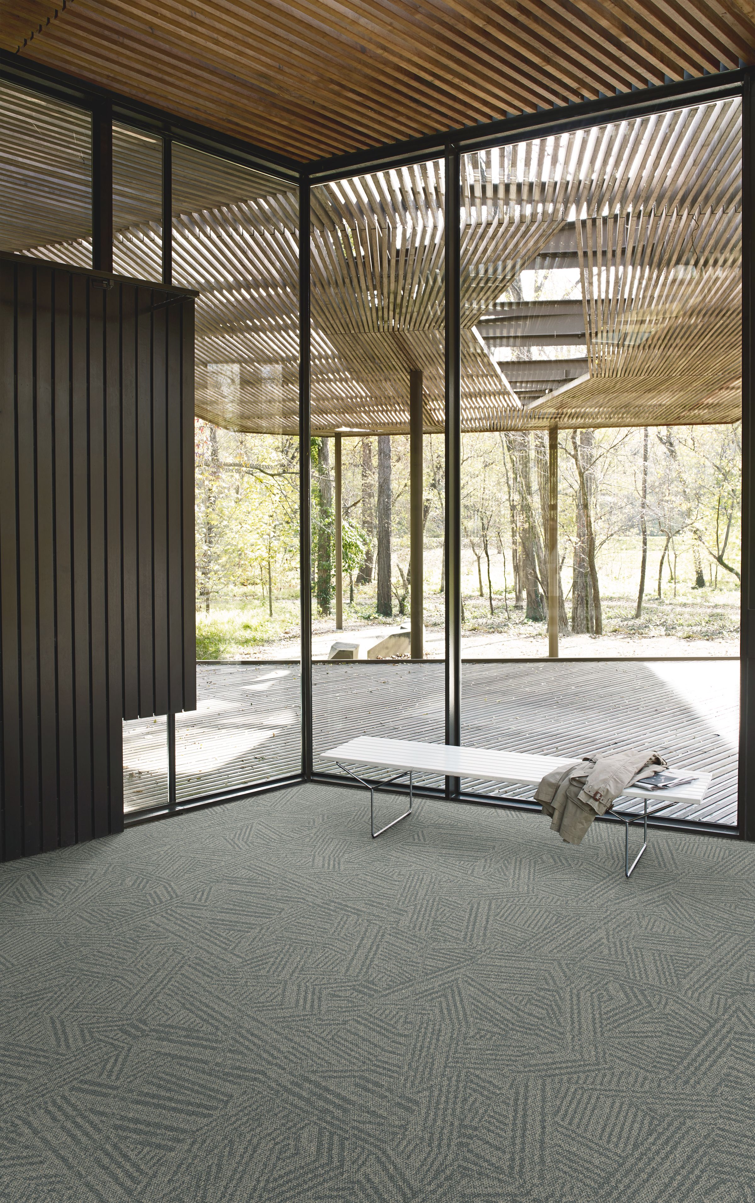 Interface Open Air 412 carpet tile in corner space with coat draped over small white bench and wood slat ceiling image number 6