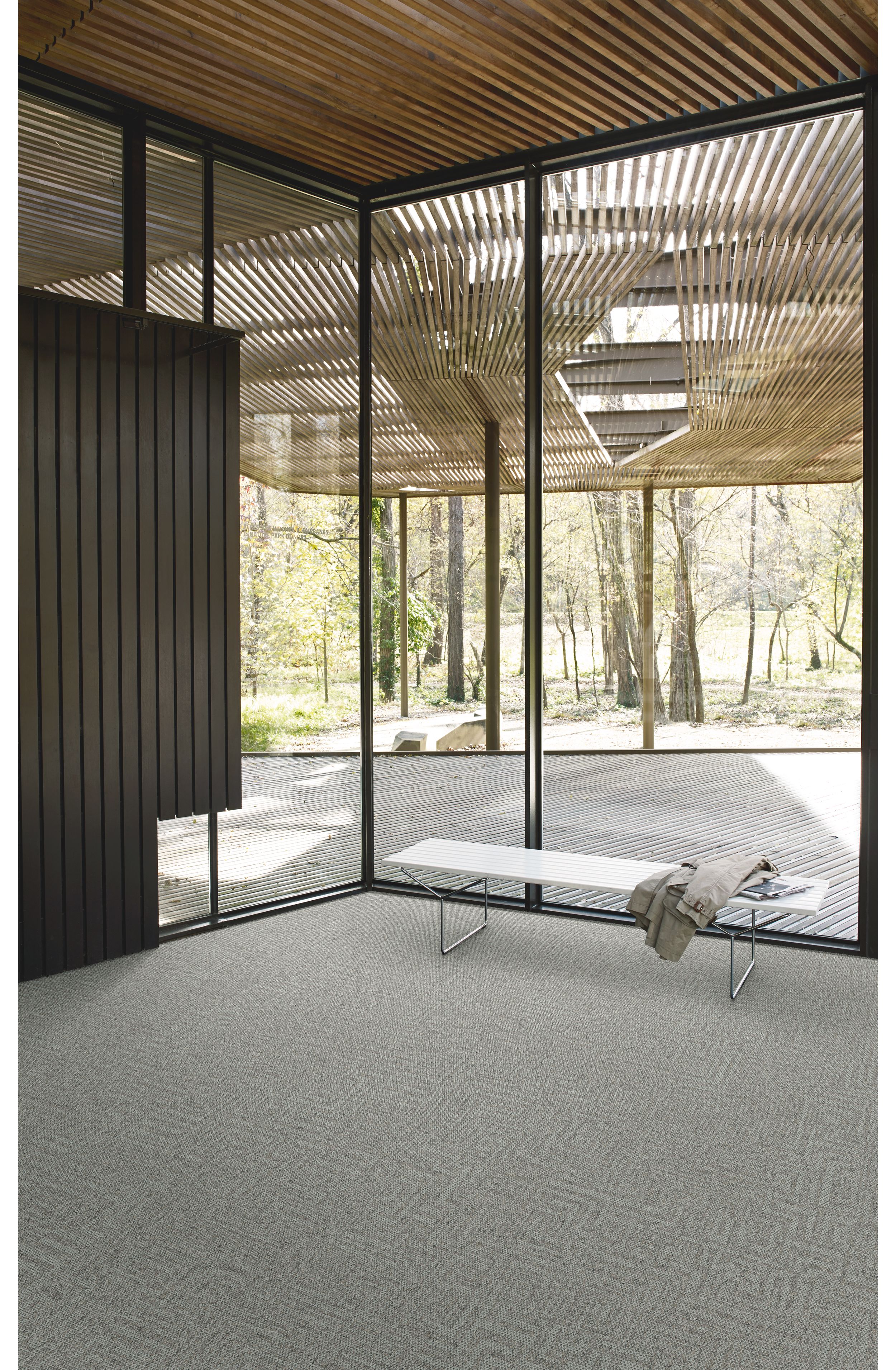 Interface Open Air 413 carpet tile in corner space with coat draped over small white bench and wood slat ceiling image number 3