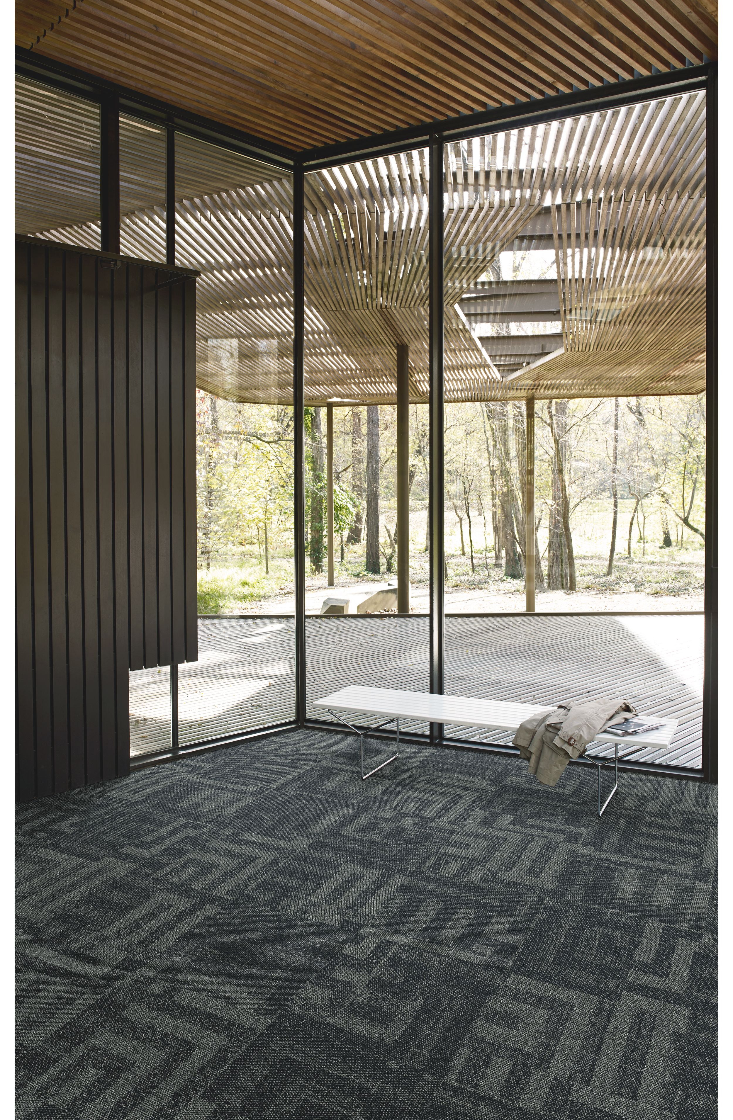 Interface Open Air 414 carpet tile in corner space with coat draped over small white bench image number 3