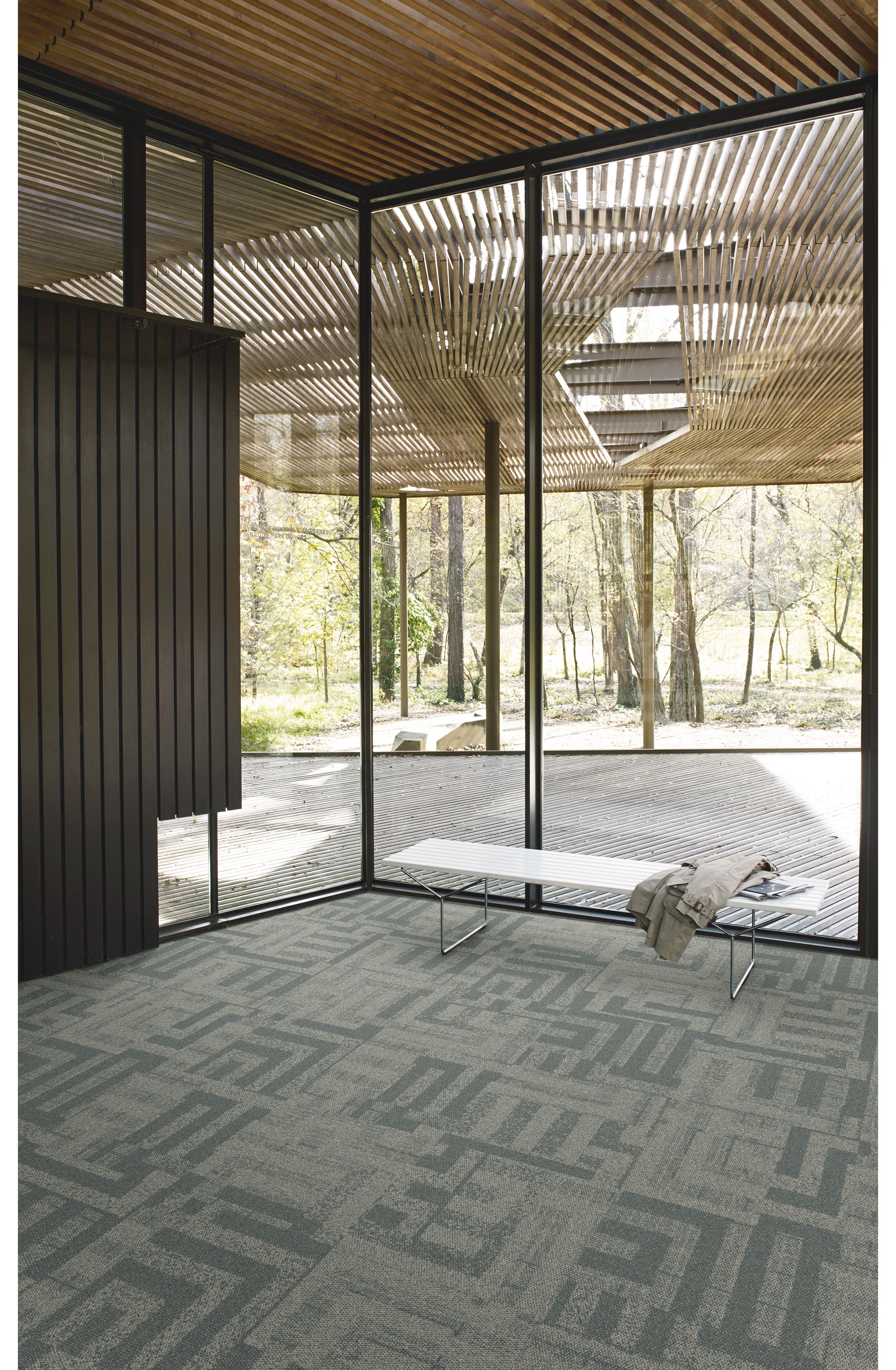 Interface Open Air 414 carpet tile in corner space with coat draped over small white bench image number 2