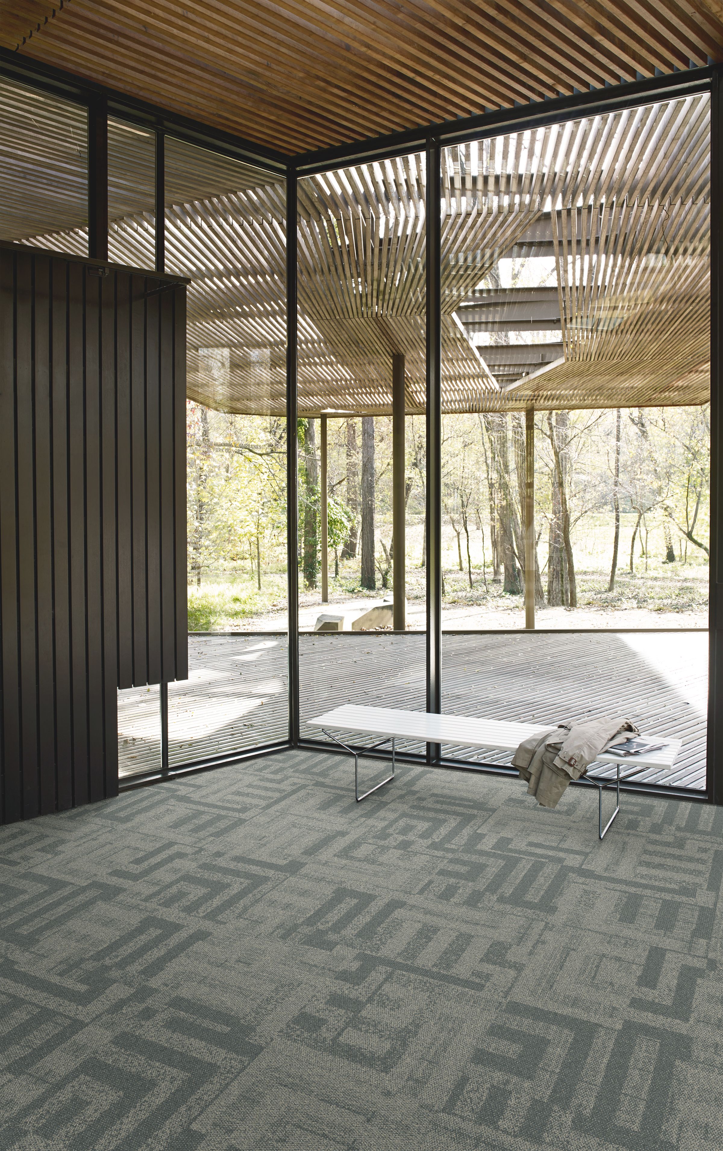 Interface Open Air 414 carpet tile in corner space with coat draped over small white bench image number 6