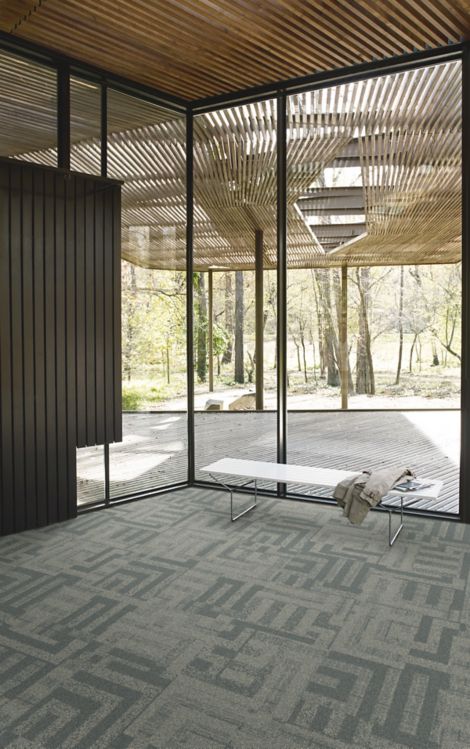 Interface Open Air 414 carpet tile in corner space with coat draped over small white bench