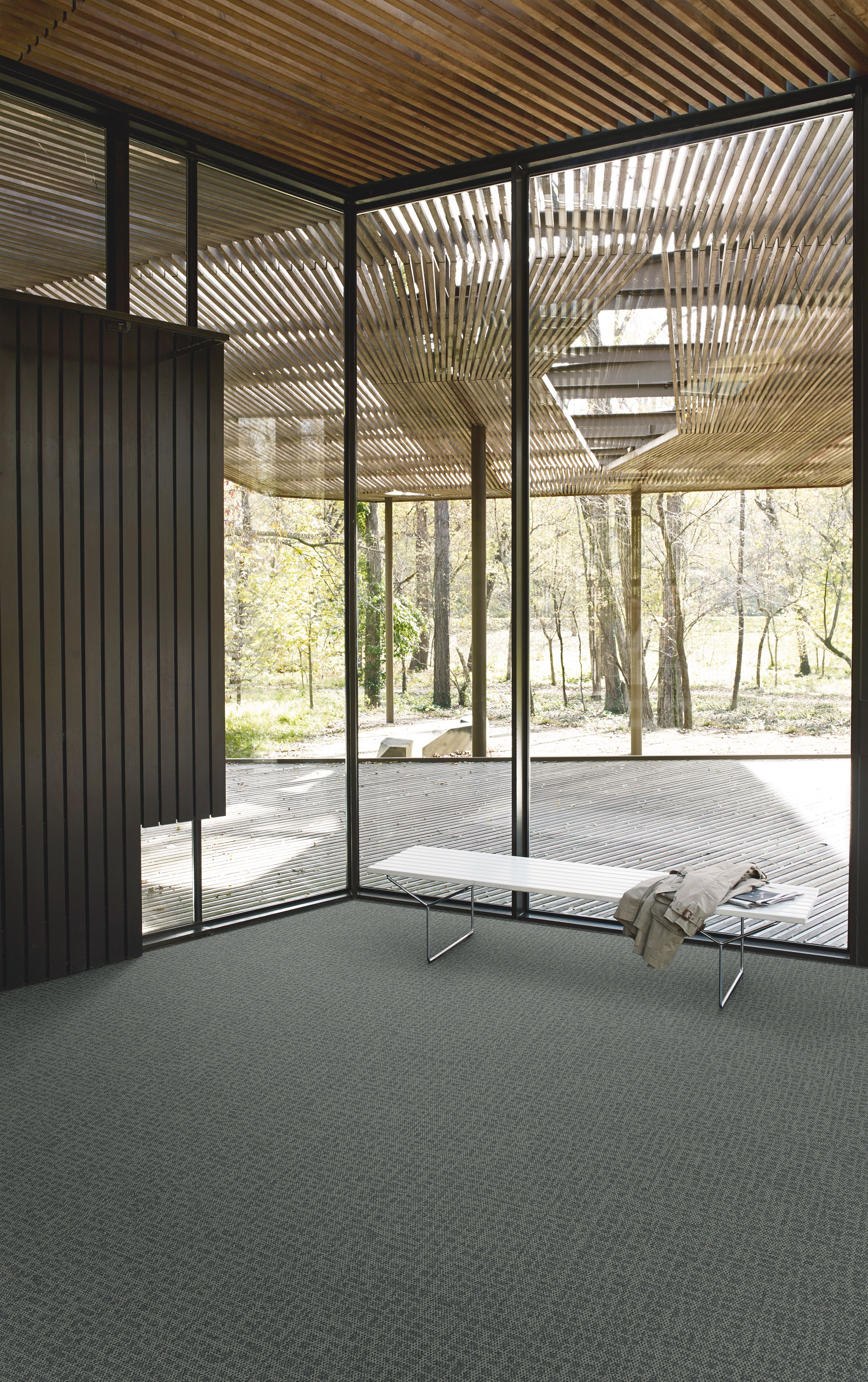Interface Open Air 415 carpet tile in corner space with coat draped over small white bench and wooden slat ceiling imagen número 5