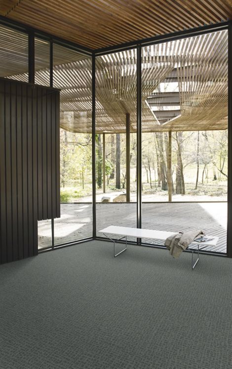 Interface Open Air 415 carpet tile in corner space with coat draped over small white bench and wooden slat ceiling