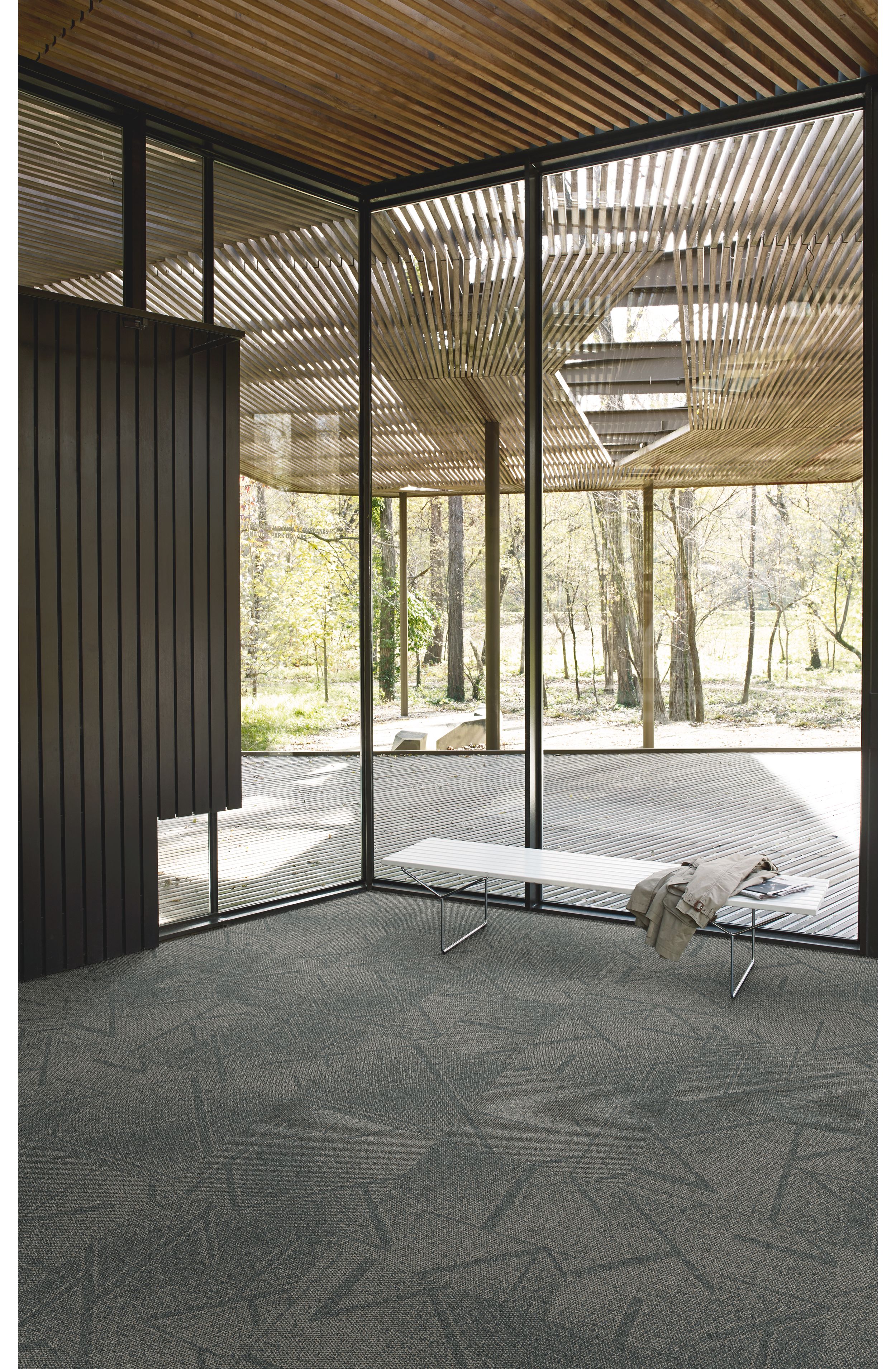 Interface Open Air 417 carpet tile in corner space with coat draped over small white bench and wooden slat ceiling imagen número 2