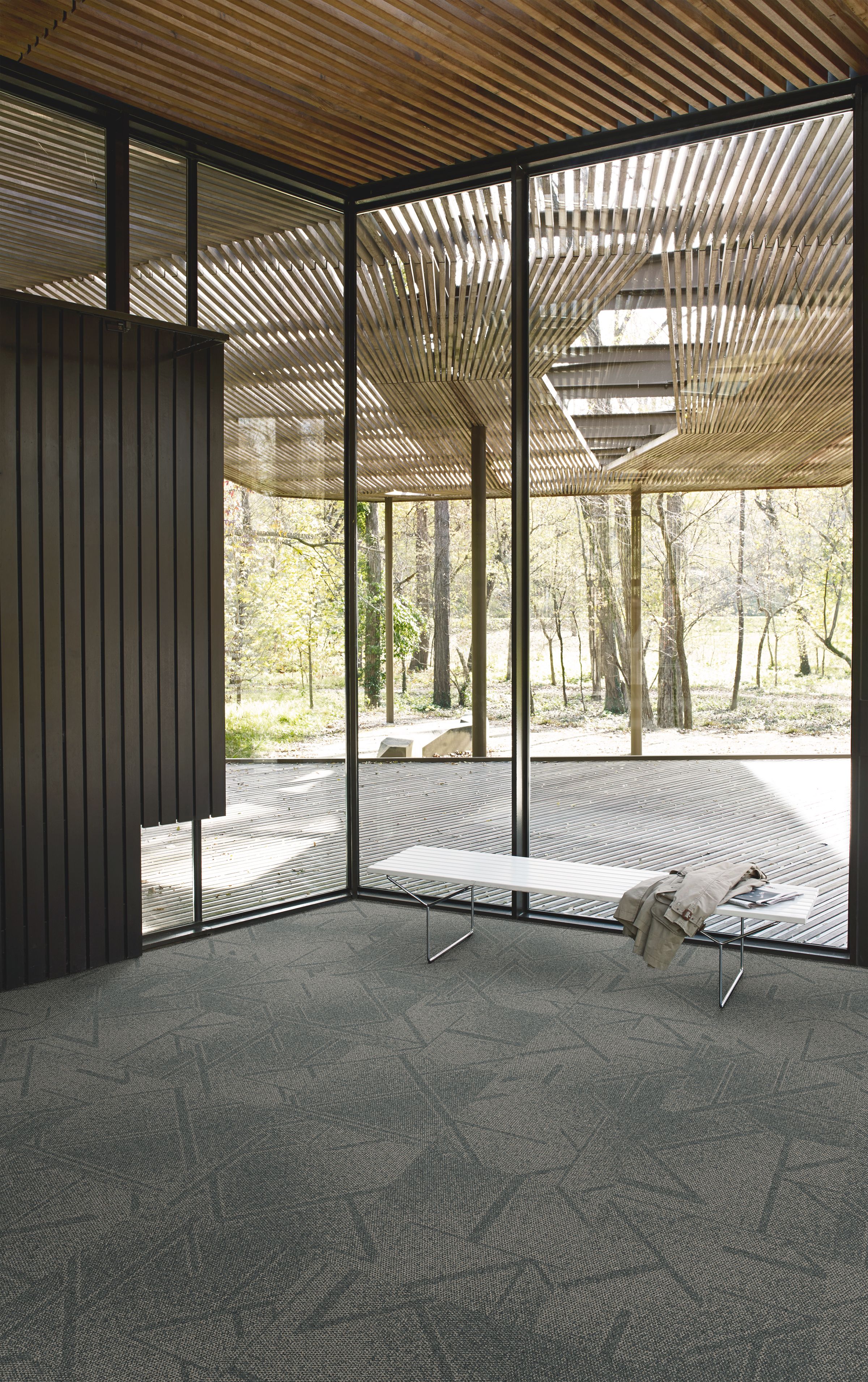 Interface Open Air 417 carpet tile in corner space with coat draped over small white bench and wooden slat ceiling imagen número 6