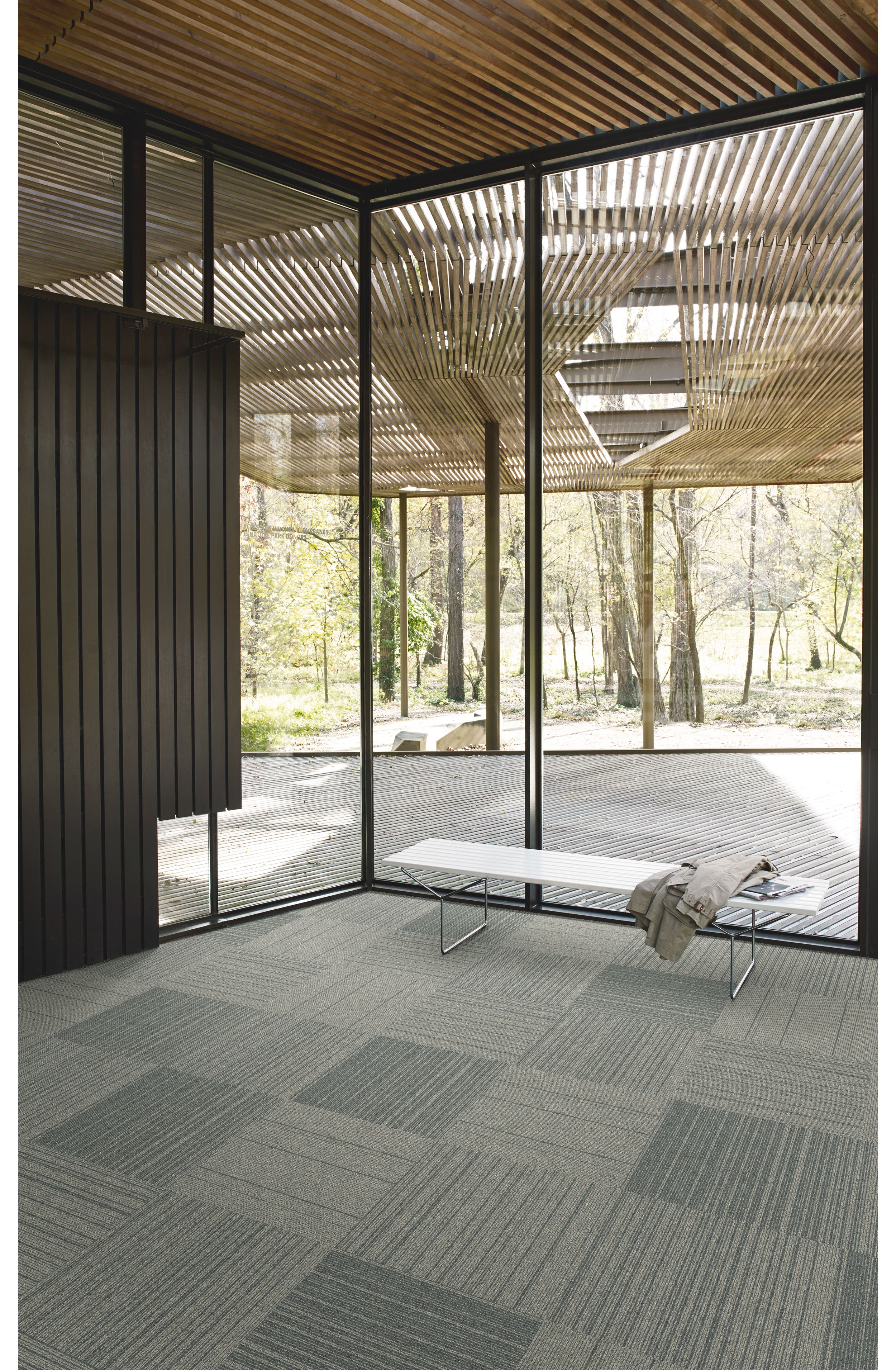 Interface Open Air 423 carpet tile in corner space with small white bench and wooden slat ceiling imagen número 3