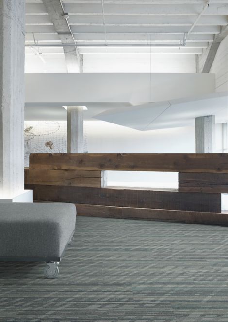 Interface Soft Glow plank carpet tile in lobby area with wood wall