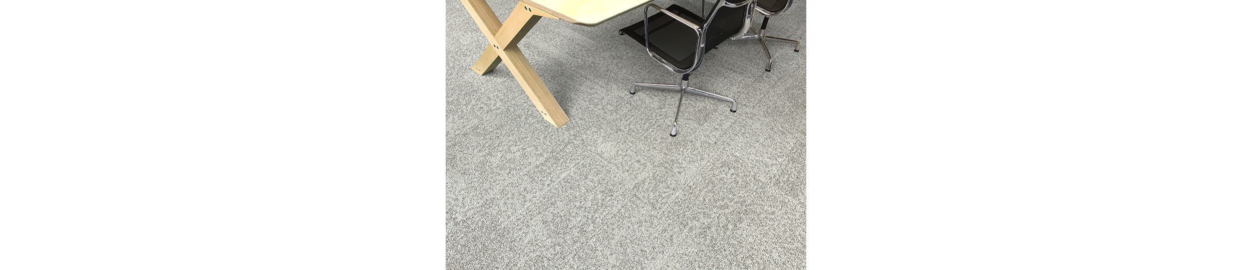 Interface Open Air 405 carpet tile in overhead view with corner of wood table and rolling chair afbeeldingnummer 3