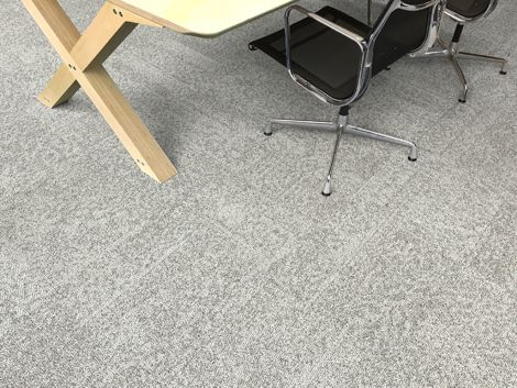 Interface Open Air 405 carpet tile in overhead view with corner of wood table and rolling chair imagen número 3