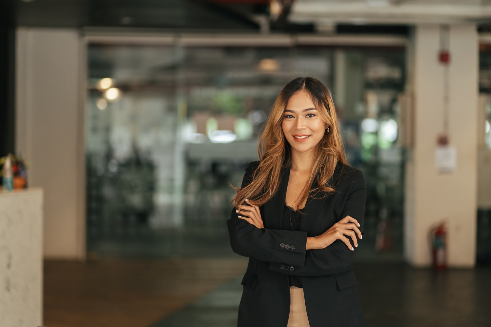 Smiling beautiful female professional manager standing with arms crossed looking at camera, happy confident business woman corporate leader boss ceo posing in office, headshot close up portrait